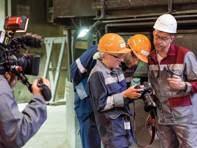 Auto newspaper journalist Markus Schönfeld, auto newspaper photographer Daniela Loof, and Mark Stagge of thyssenkrupp Steel look at the camera’s display and examine the photographed motif.