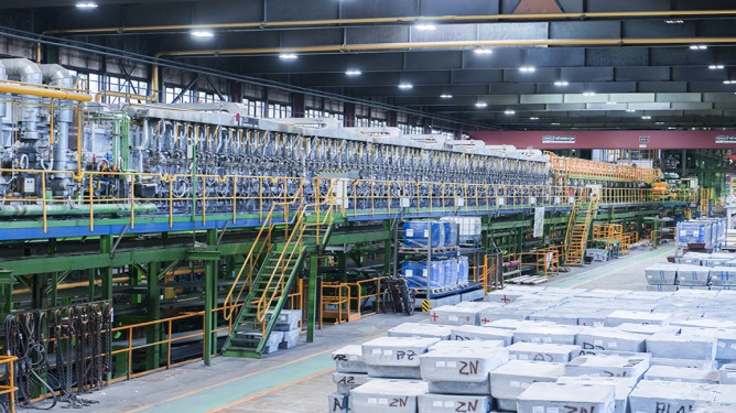 Production hall at thyssenkrupp Steel's Kreuztal site with multi-story production line and machinery.