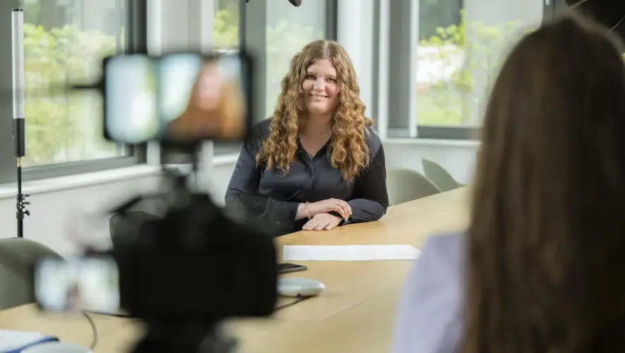 Pia Fork is being interviewed at thyssenkrupp Steel in a modern office. A camera is recording the conversation. Pia Fork is being interviewed at thyssenkrupp Steel in a modern office. A camera is recording the conversation.