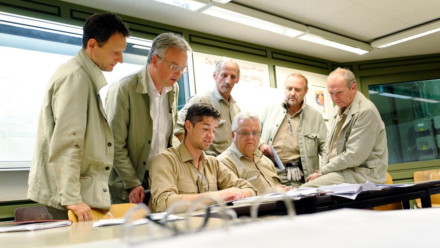 thyssenkrupp Steel employees sit together at a table in a meeting room and discuss documents