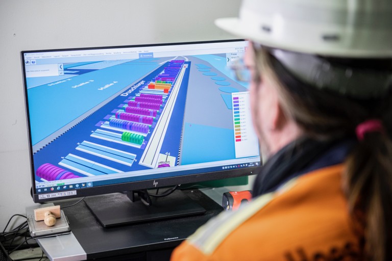 Employee manages the digital warehouse at Precision Steel Employee manages the digital warehouse at Precision Steel