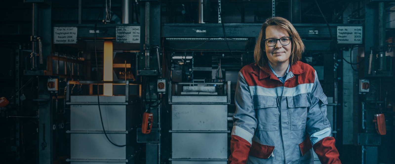 Mitarbeiterin in Schutzkleidung in einem industriellen Umfeld bei thyssenkrupp Steel. 