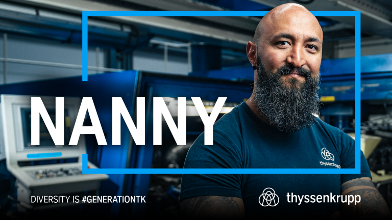 A thyssenkrupp employee in a dark blue T-shirt stands in an industrial setting. The image features the words “NANNY,” “DIVERSITY IS #GENERATIONTK,” and the thyssenkrupp logo. A thyssenkrupp employee in a dark blue T-shirt stands in an industrial setting. The image features the words “NANNY,” “DIVERSITY IS #GENERATIONTK,” and the thyssenkrupp logo.