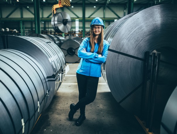Employee at thyssenkrupp in an industrial environment with coils and production facilities. Employee at thyssenkrupp in an industrial environment with coils and production facilities.