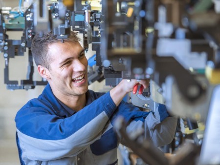 Auszubildender bei thyssenkrupp Steel bei der Arbeit an einer Maschine mit Werkzeug. Auszubildender bei thyssenkrupp Steel bei der Arbeit an einer Maschine mit Werkzeug.