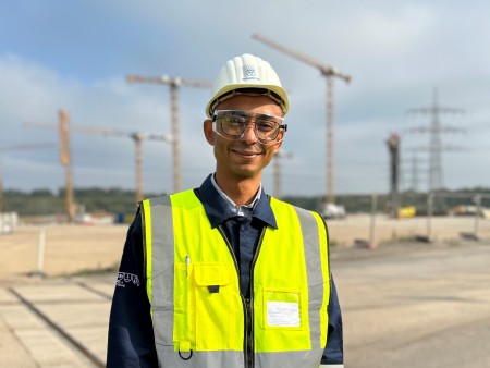 Belhassen Charfi wearing safety gear including a helmet and high-visibility vest at a construction site at thyssenkrupp Steel. Belhassen Charfi wearing safety gear including a helmet and high-visibility vest at a construction site at thyssenkrupp Steel.